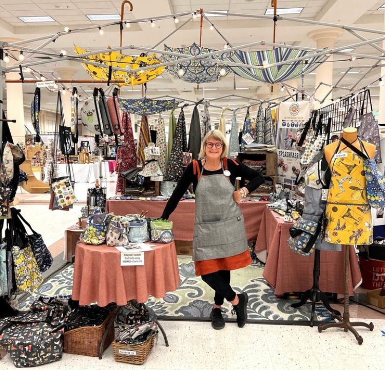 Tracy Krauter of Splash Fabric standing in her booth at Urban Craft Uprising