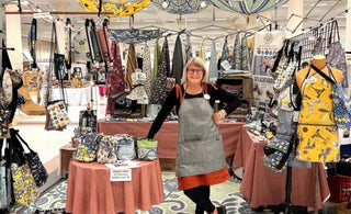 Tracy Krauter of Splash Fabric standing in her booth at Urban Craft Uprising
